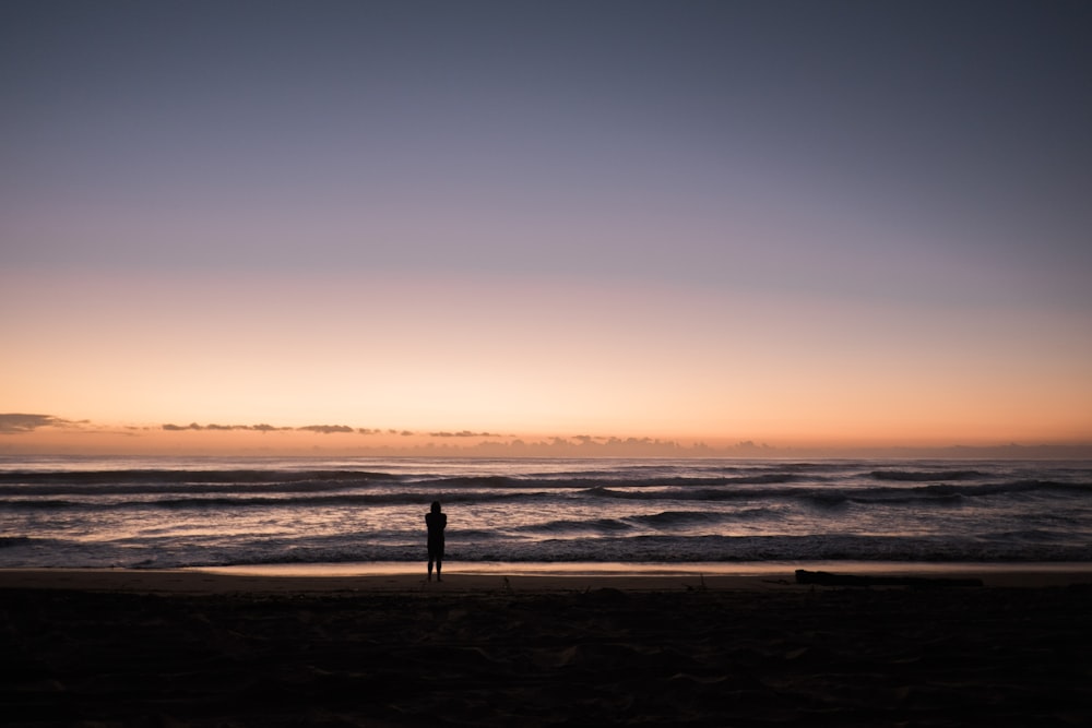 Persona en la playa durante la puesta de sol