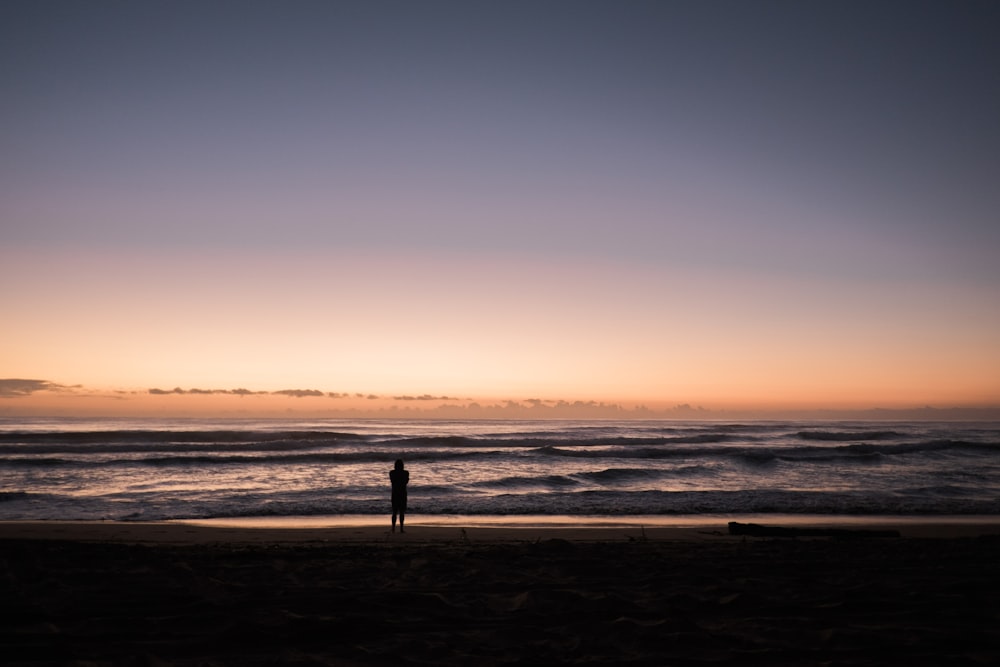 pessoa na praia durante o pôr do sol