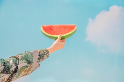 person holding sliced watermelon fresh teams background