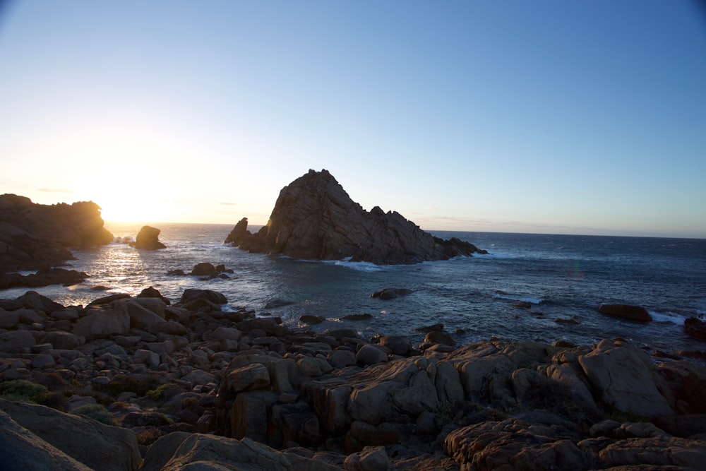 aerial photography of rock islet near sea shore