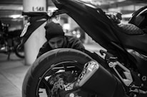 A biker inspecting various motorcycle components in a cozy garage setting.