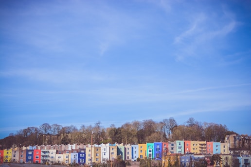 A row of houses showcasing roofs in vibrant reds, blues, and greens under a clear sky.