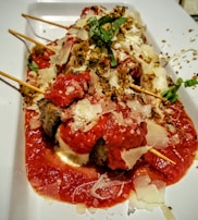 Traditional Turkish meatballs sizzling on a grill with herbs.