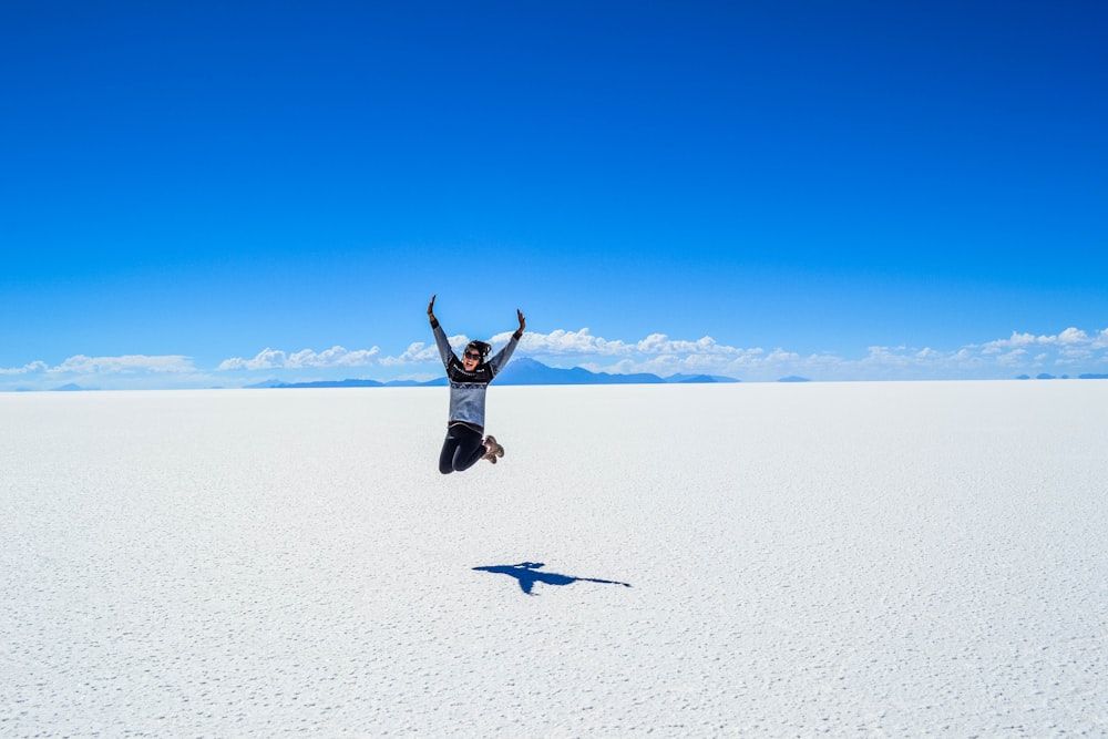 woman jumping under blue skyt