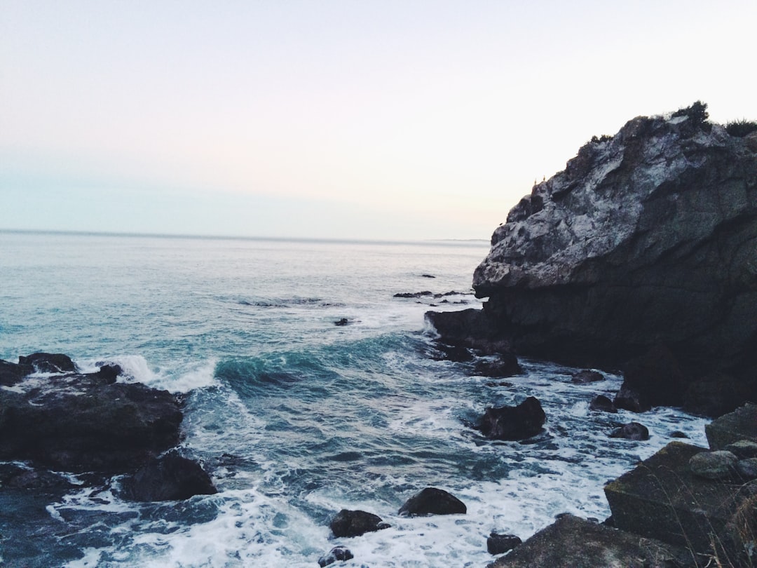 ocean waves near rocks during daytime