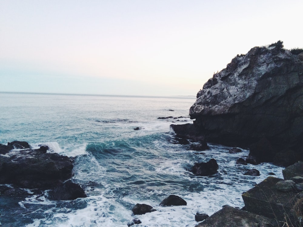 onde dell'oceano vicino alle rocce durante il giorno