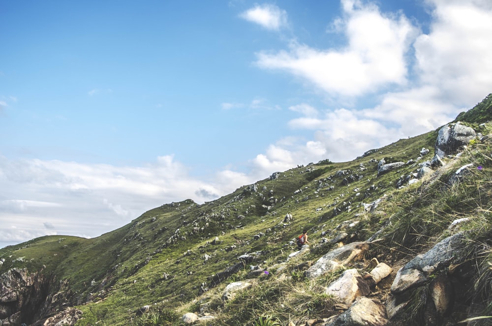 persona che cammina sulla montagna durante il giorno