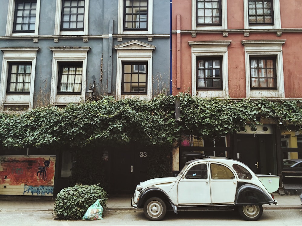 white car parked beside brown building