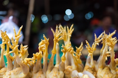 A display of chicken legs neatly arranged on a market counter under warm lighting.