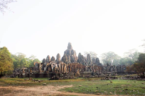 Ancient temple ruins framed by lush greenery and soft morning mist