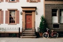 red bicycle parked beside black metal gate in front house