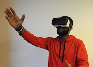 man wearing white VR headset while lifting right hand