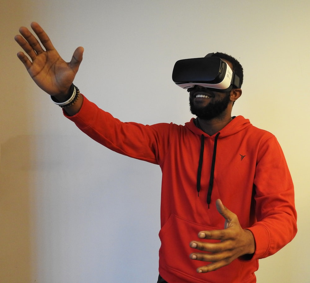 uomo che indossa un visore VR bianco mentre solleva la mano destra