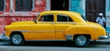 yellow sedan parked near red concrete building