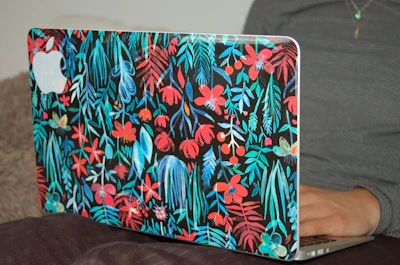 Close-up of a burgundy custom vinyl decal featuring a delicate floral design on a laptop.