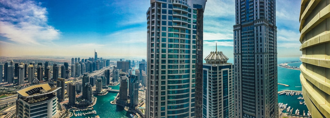 high rise buildings near body of water under blue sky