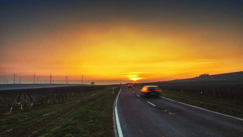 black car on road during sunset