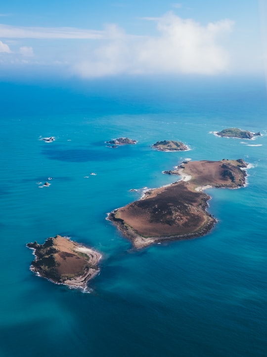 brown island on body of water under cloudy sky in Isles of Scilly United Kingdom