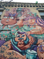 Colorful urban mural painted on a brick wall in Toluca, showcasing vibrant characters and street vibe.