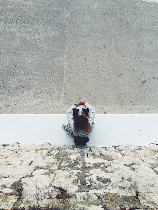 top view of person sitting near gray rock wall during daytime in Žurkovo Croatia