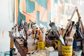 assorted-color paint brush on brown wooden table top