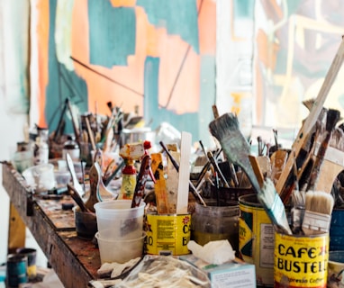 assorted-color paint brush on brown wooden table top