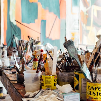 assorted-color paint brush on brown wooden table top