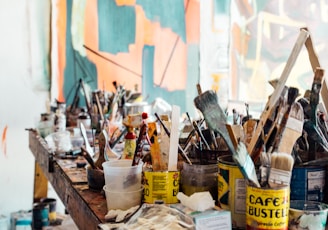 assorted-color paint brush on brown wooden table top