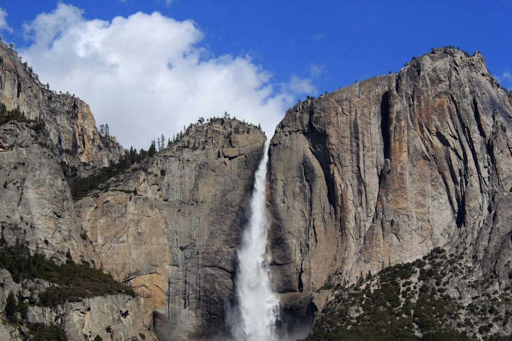 waterfalls between gray stone mountain