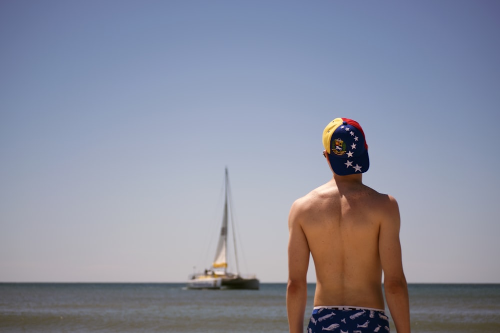 man standing facing boat during daytime