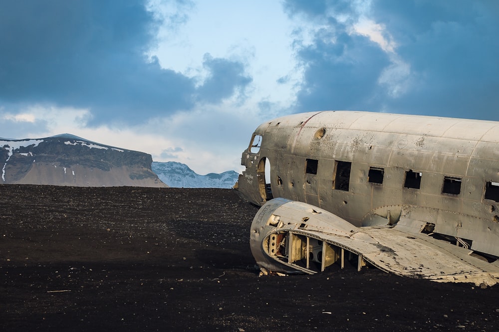 white airplane crush on land under cloudy sky