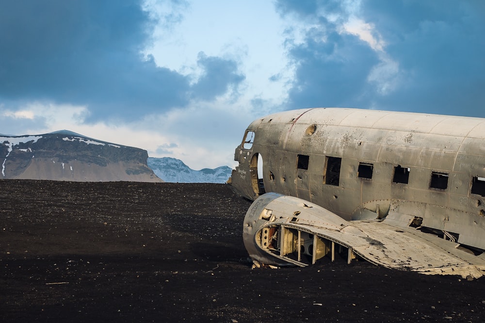 Abandoned airplane wreckage by a mountain landscape