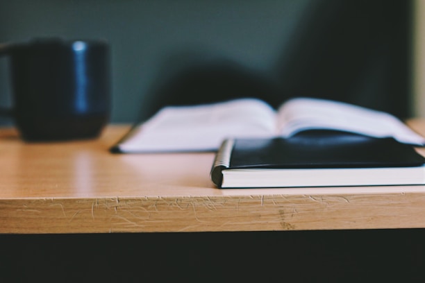 Close-up of study materials and notes with a cup of coffee on a wooden desk.