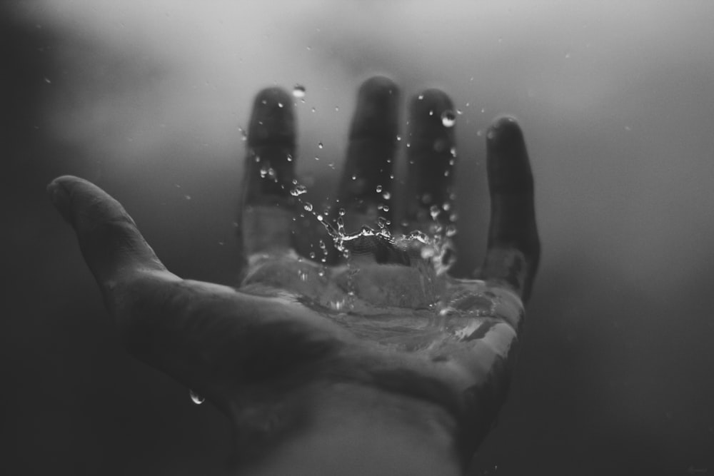 Zeitrafferfotografie von Wasser, das auf die linke Handfläche trifft