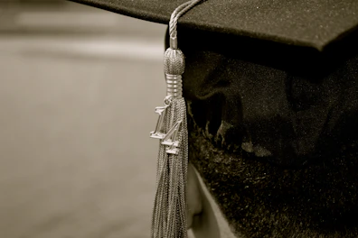 Close-up of a classic black graduation cap with a golden tassel.