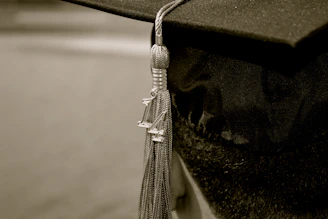 Close-up of a classic black graduation cap with a golden tassel.