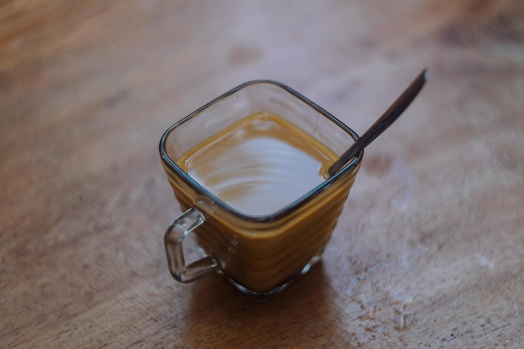 clear glass mug with brown liquid