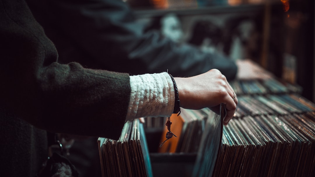 person picking up the music record, Browsing record store shelves