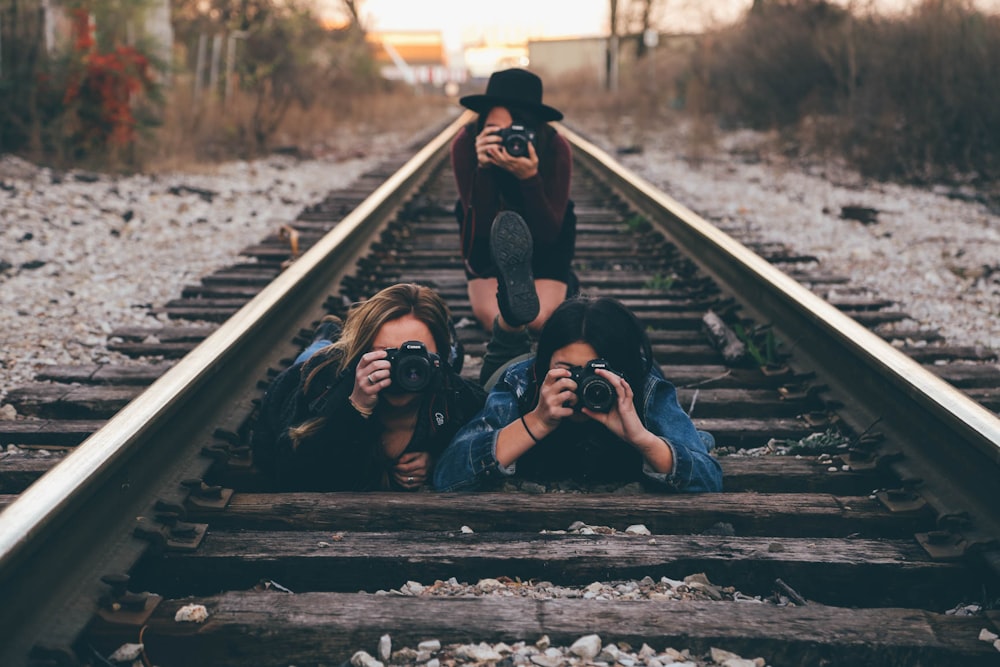 tres mujeres en el ferrocarril del tren tomando una foto