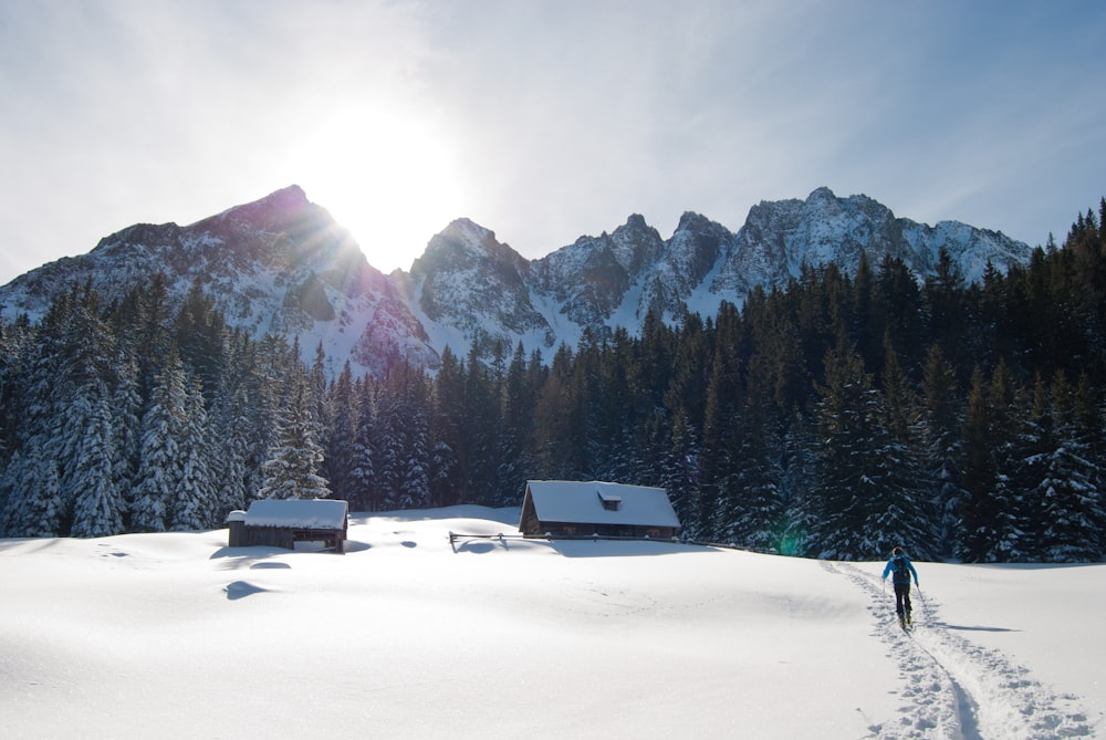 person walking on snowfield near mountain range