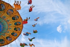 people riding carnival ride under blue skies