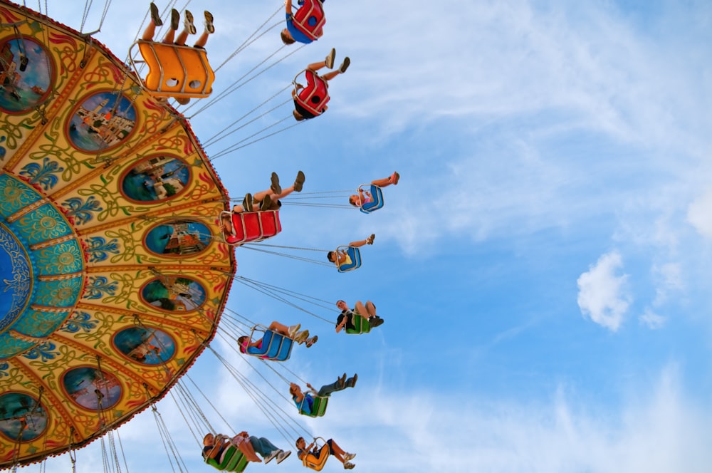 La gente monta el paseo de carnaval bajo el cielo azul