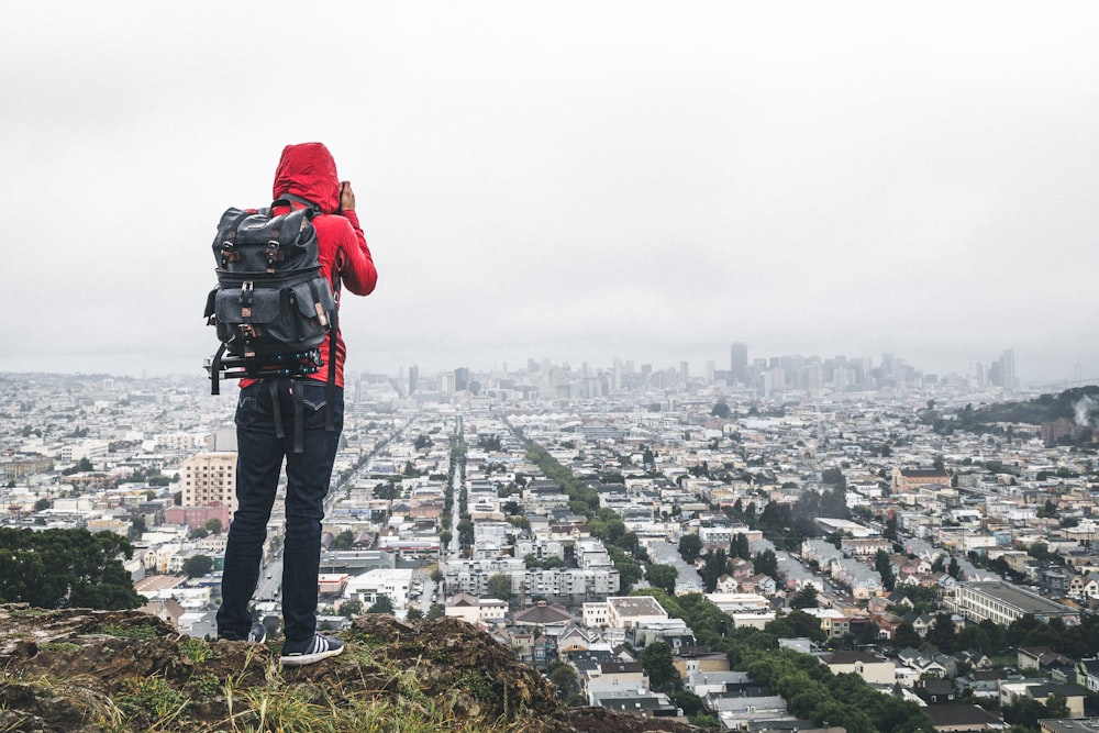 Persona che si leva in piedi sulla scogliera sopra la città