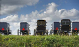 A group of buggies parked near a forest trail at sunset.