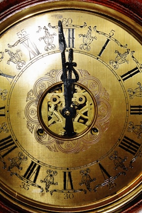 A close-up of a vintage clock with intricate details and a worn patina.