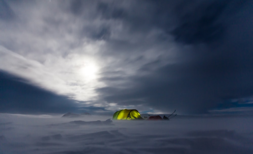 green tent in the middle of snow field
