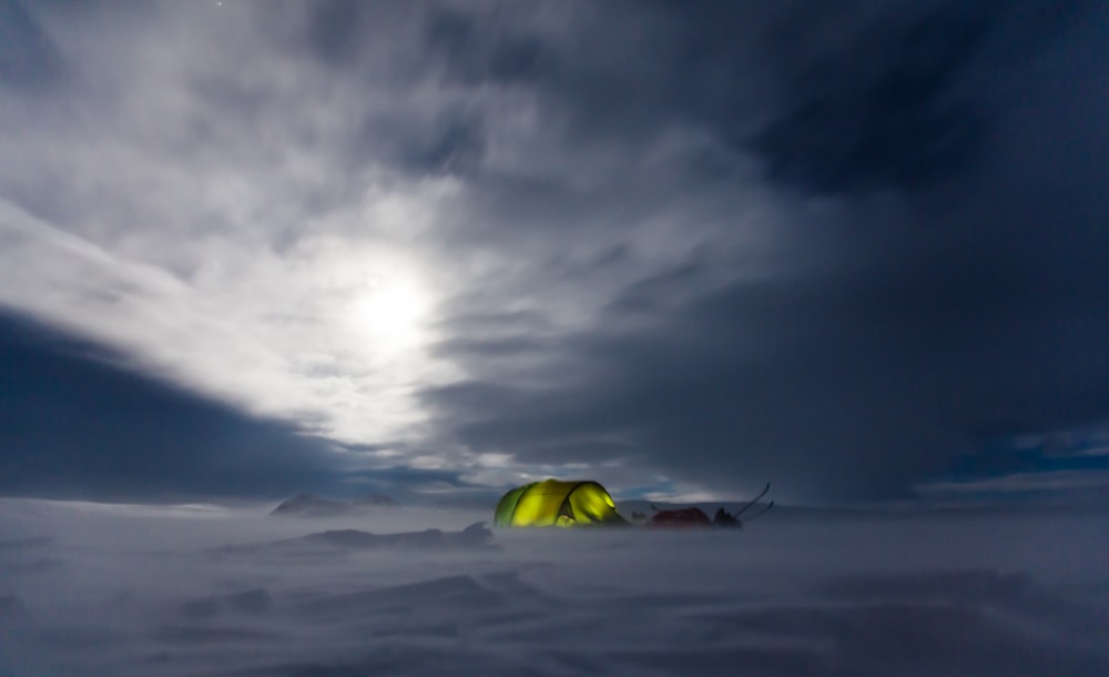 tenda verde nel mezzo del campo di neve