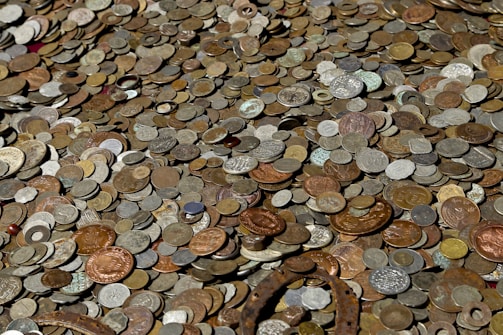 Assortment of silver coins spread out on a wooden table.