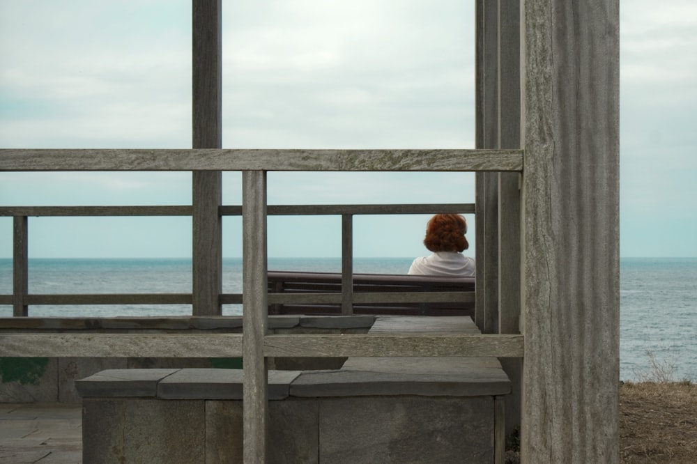 woman in white long sleeve shirt sitting on gray concrete stairs