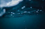 Deep underwater scene capturing the texture and movement of water, with bubbles and a play of light creating an ethereal atmosphere.